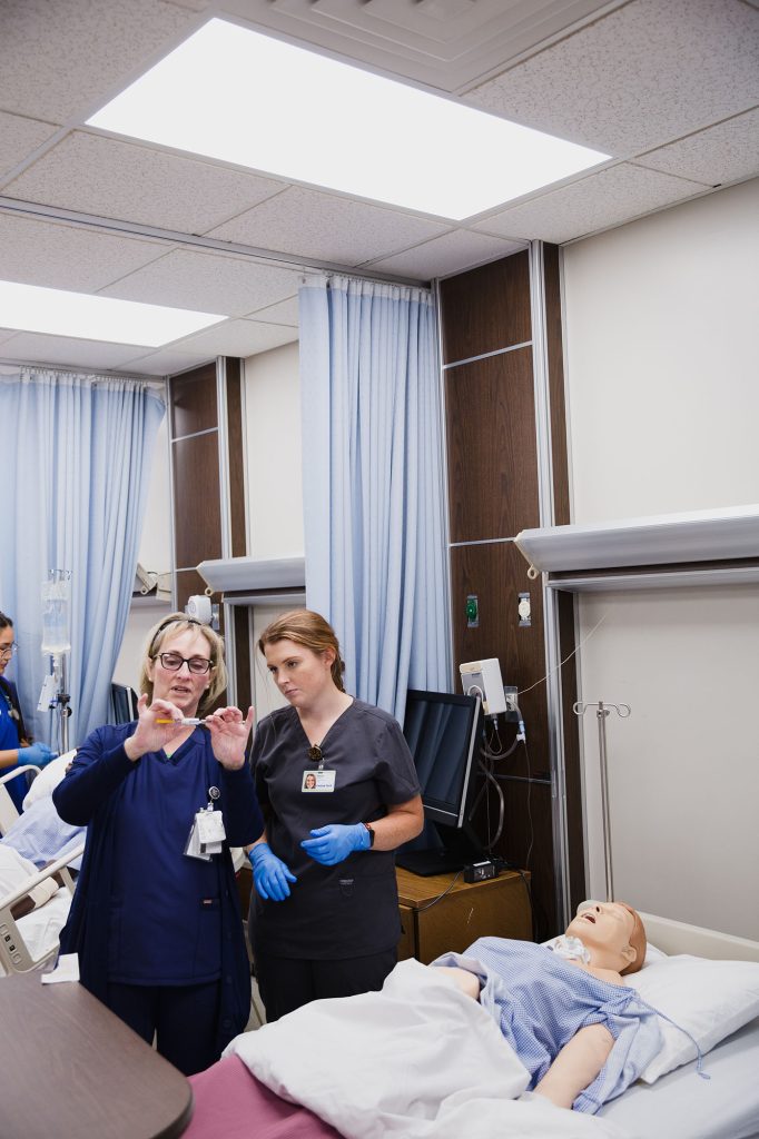 Practical Nursing teacher showing a student how to check an injection
