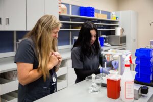 happy teacher watches student practice compounding prescription