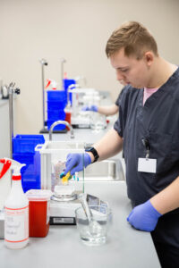 male pharmacy technician student at central tech weighs medication