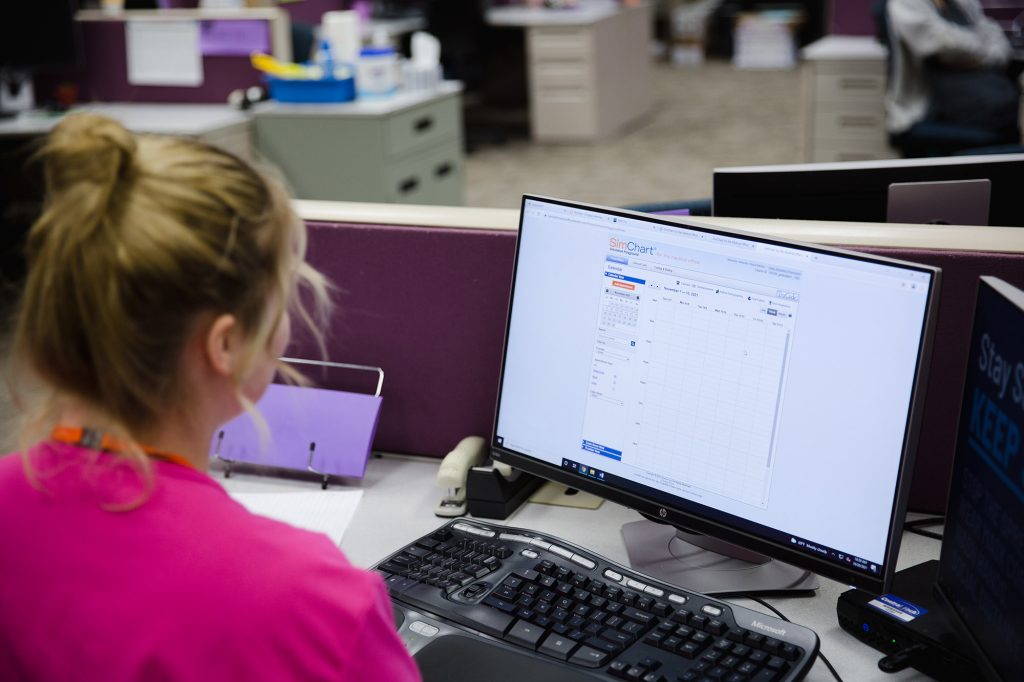 medical office student logging a patients visit and bill in the computer at Central Tech