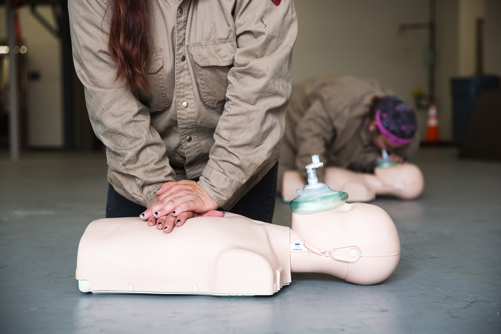 person doing CPR compressions on a dummy at Central Tech