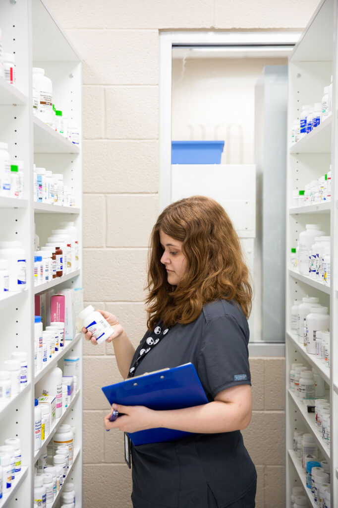 pharmacy technician student looks for prescription on shelves