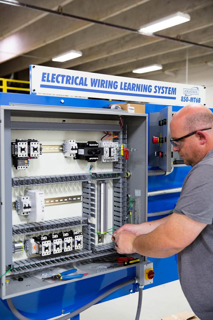 student learning on the electrical wiring learning system in the Automation Technician class at Central Tech
